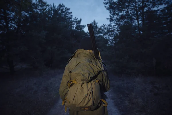 Cazador barbudo con equipo profesional caminando por el bosque — Foto de Stock