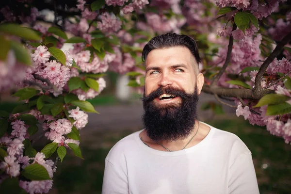 Bir neşeli sakallı adam güzel bıyıklı sakura yakınlarında şık bir hairdress çıkar