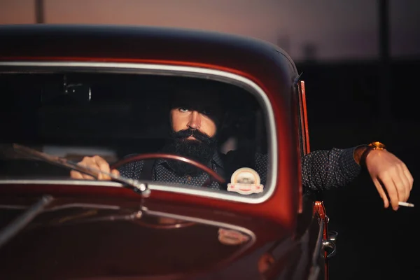 Homem barbudo elegante sentado em uma cabine de um carro antigo — Fotografia de Stock
