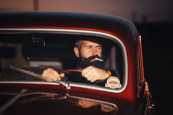 Homem barbudo elegante sentado em uma cabine de um carro antigo — Fotografia de Stock