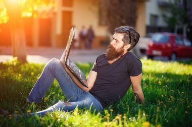  onun elinde bir dizüstü bilgisayar ile sakallı işadamı