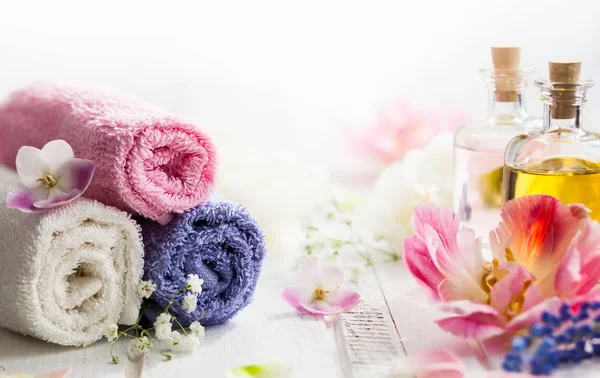 Aroma oil with towels and flowers — Stock Photo, Image