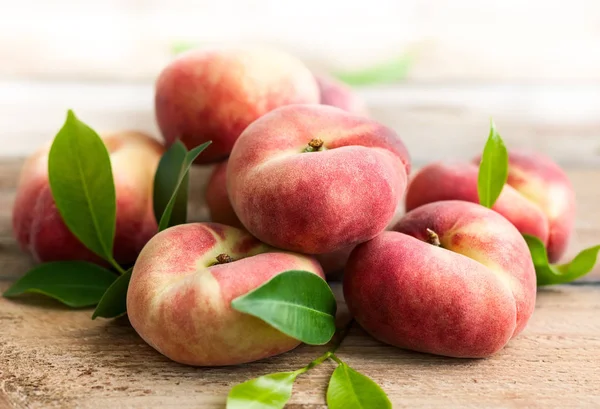 Frische Pfirsiche auf Holztisch — Stockfoto