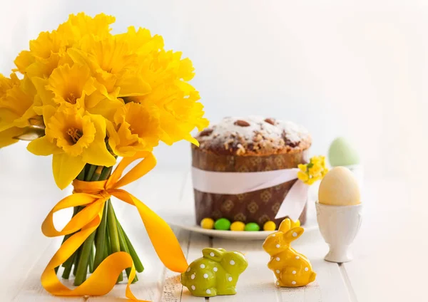 Wielkanoc bukiet żółte żonkile i ciasto wielkanocne. — Zdjęcie stockowe