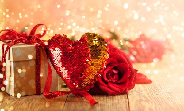 Confezione regalo con fiocco a nastro rosso e rose rosse . — Foto Stock