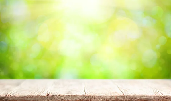 Mesa de madera y fondo borroso verde primavera o verano. Este. —  Fotos de Stock