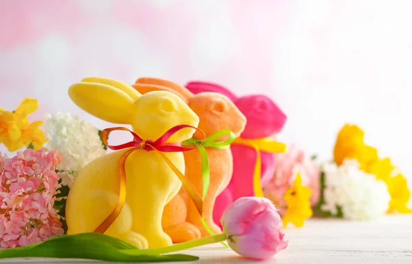 Пасхальное украшение с пасхальными красочными кроликами и весенним цветком — стоковое фото