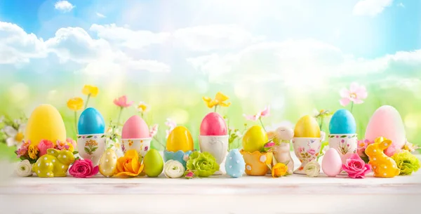 Пасхальная концепция с красочными украшенными яйцами в чашки и поток — стоковое фото