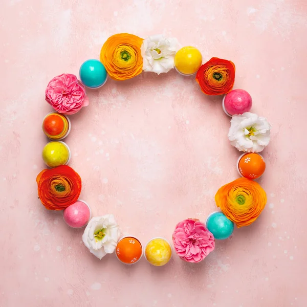 Paskalya yumurtaları ve halka şeklinde yapılmış renkli bahar çiçekleri. — Stok fotoğraf