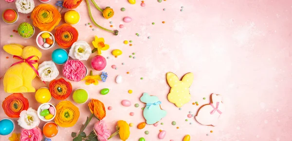 Påskägg, kanin, godis och färgglada vårblommor på pastell — Stockfoto