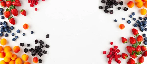 stock image Fresh organic apricots, strawberry, blueberry and blackberry on white background. Vegetarian, clean and healthy eating concept. Flat lay, copy space.