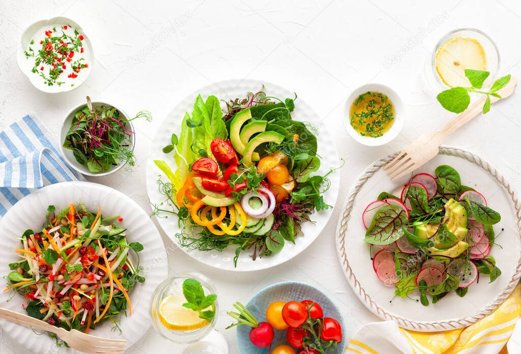 Various healthy salads of fresh vegetables,fruits and microgreens on table. Clean eating, lunch bowl. Top view. Concept taste of home meal.