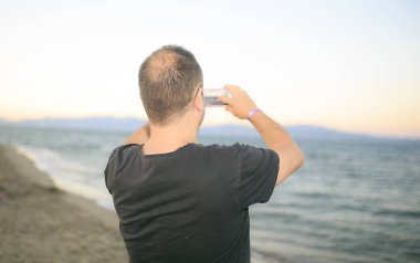  adam sahilde mobile ile fotoğraf çekmek