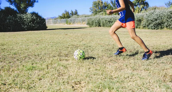 Çocuklar parkta futbol oynuyorlar.