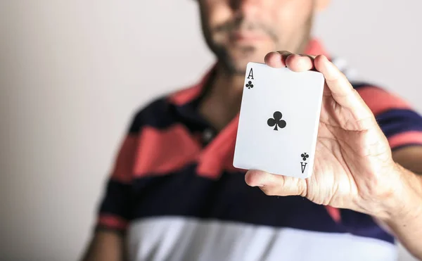 Homem mostrando carta de baralho em sua mão — Fotografia de Stock