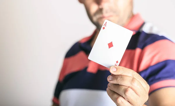 Homem mostrando carta de baralho em sua mão — Fotografia de Stock
