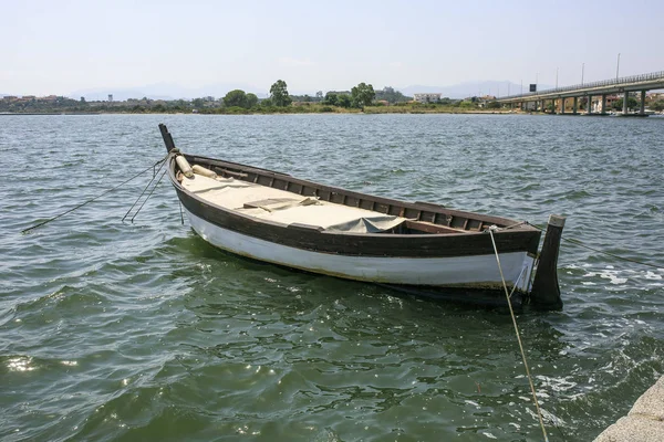 Pequeno barco de madeira em um lado do rio — Fotografia de Stock
