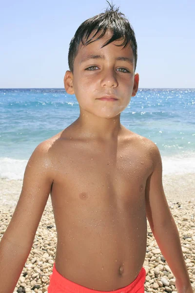 Menino com belos olhos verdes na praia — Fotografia de Stock