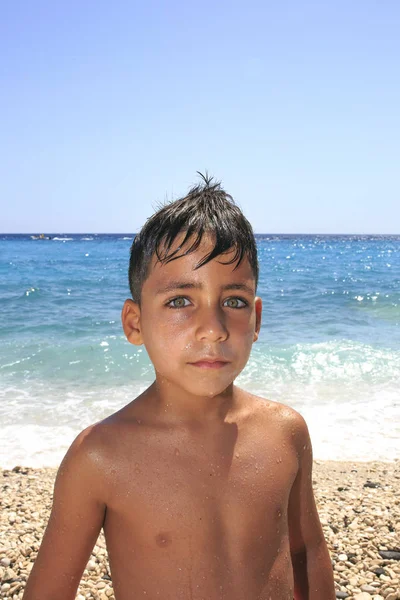 Мальчик с красивыми зелеными глазами на пляже — стоковое фото