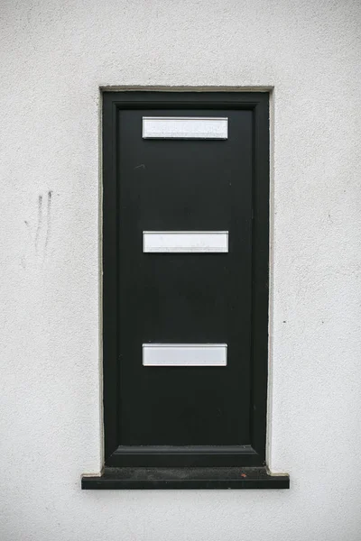 Beyaz bir duvar içinde siyah postbox — Stok fotoğraf