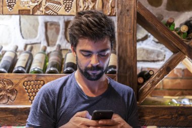 Handsome bearded man using his mobile in a restaurant