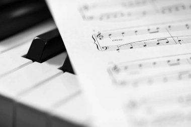 Klasik piyano ve müzik sayfası. Siyah beyaz fotoğraf, müzikal arkaplan
