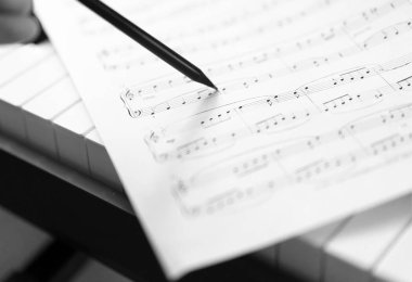 kalem ve müzik sayfası - müzikal arka plan ile el