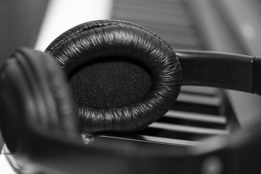 Müzik sentezleyici klavyesinde kulaklık. Kulaklıklar elektronik piyanoda. Müzik arkaplanı
