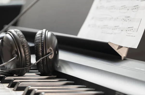 Auriculares con teclado sintetizador musical. Auriculares en piano electrónico. Fondo musical —  Fotos de Stock