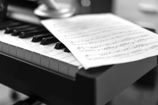 Электронное фортепиано и ноты. Черно-белое фото, Музыкальный фон — стоковое фото