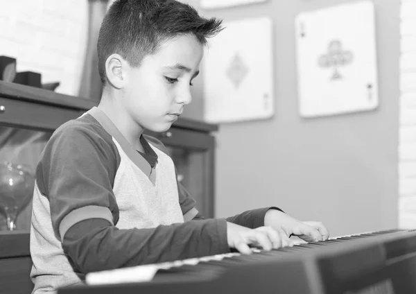 Kleiner Junge spielt klassisches Klavier im heimischen Wohnzimmer — Stockfoto