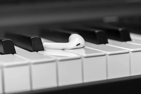 Auriculares con teclado sintetizador musical. Auriculares en piano electrónico. Fondo musical —  Fotos de Stock
