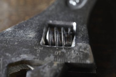 Ayarlanabilir İngiliz anahtarı ahşap arka planda izole edildi. Makro fotoğrafçılık