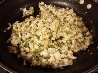 frying pan with fish and oil and green peppers and onion