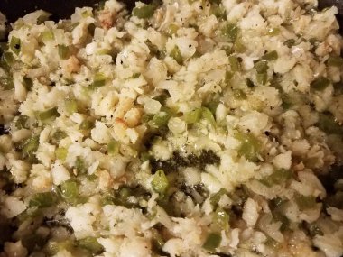 frying pan with fish and oil and green peppers and onion