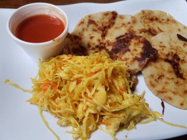 Pupusa ya da lahana ve domates sosuyla doldurulmuş peynirli tortilla.
