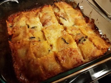 Fırında peynirli ravioli fırının üzerinde cam kabın içinde.