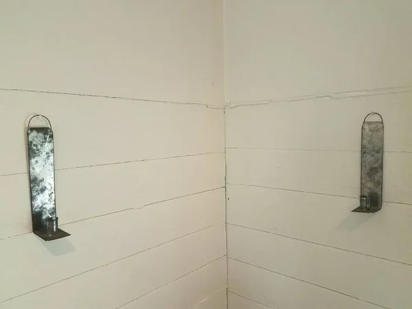 Weiße Wand mit Linien und Metallkerzenständern — Stockfoto