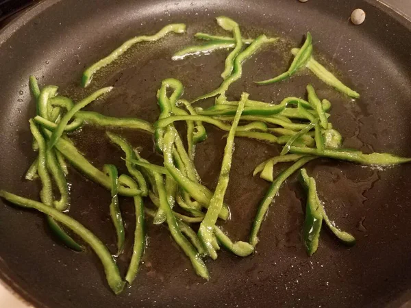 Φέτες πράσινο πιπεριές με λάδι στο τηγάνι στο φούρνο — Φωτογραφία Αρχείου