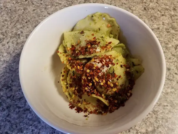 Tigela de ravioli com queijo e pimentas vermelhas e pesto — Fotografia de Stock