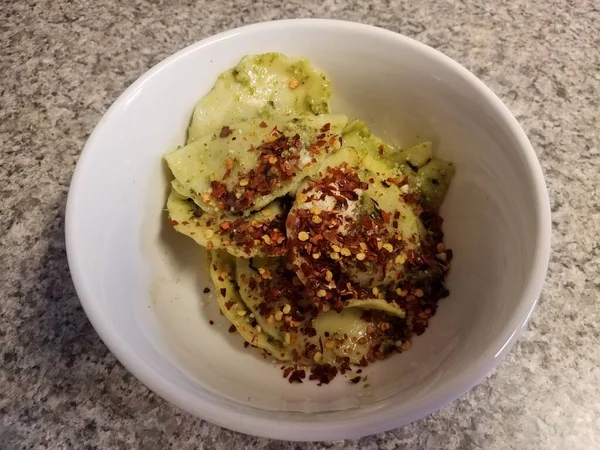 Tigela de ravioli com queijo e pimentas vermelhas e pesto — Fotografia de Stock