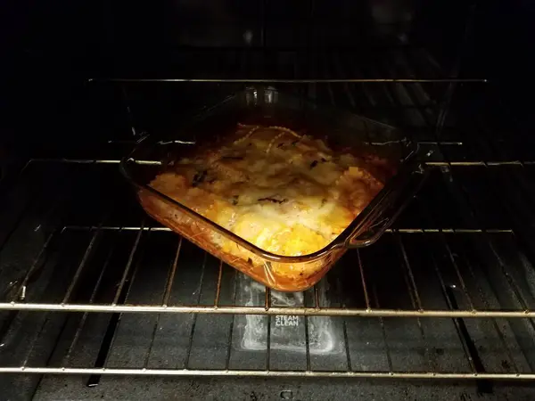 Ravioli with cheese in glass container in oven — Photo