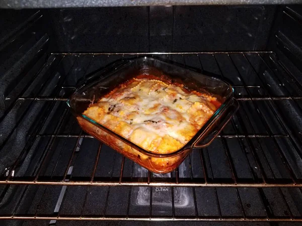 Ravioli with cheese in glass container in oven — Stock Fotó
