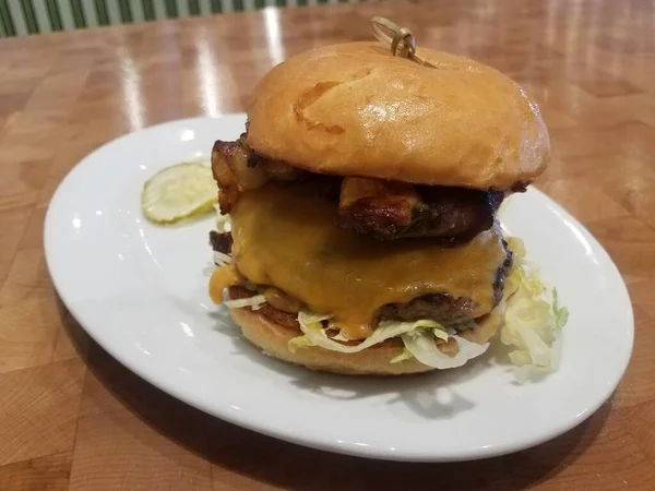 Гамбургер з сиром на тарілці з беконом та фаршированим перцем — стокове фото