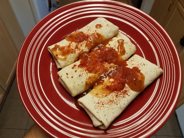 Burritos em chapa vermelha com salsa picante e pimenta em pó — Fotografia de Stock