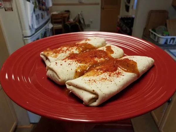 Burritos em chapa vermelha com pimentas vermelhas e salsa — Fotografia de Stock