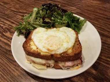 Jambonlu, peynirli ve tabakta salatalı sandviç.