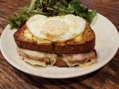 Jambonlu, peynirli ve tabakta salatalı sandviç.