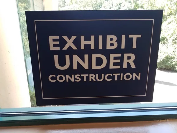Exhibit under construction sign on glass window — Stock Photo, Image