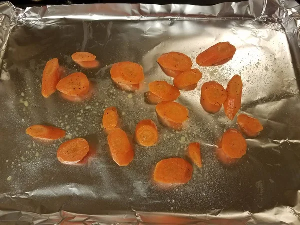 Oranžové plátky mrkve na kovové fólii v misce na pečení — Stock fotografie